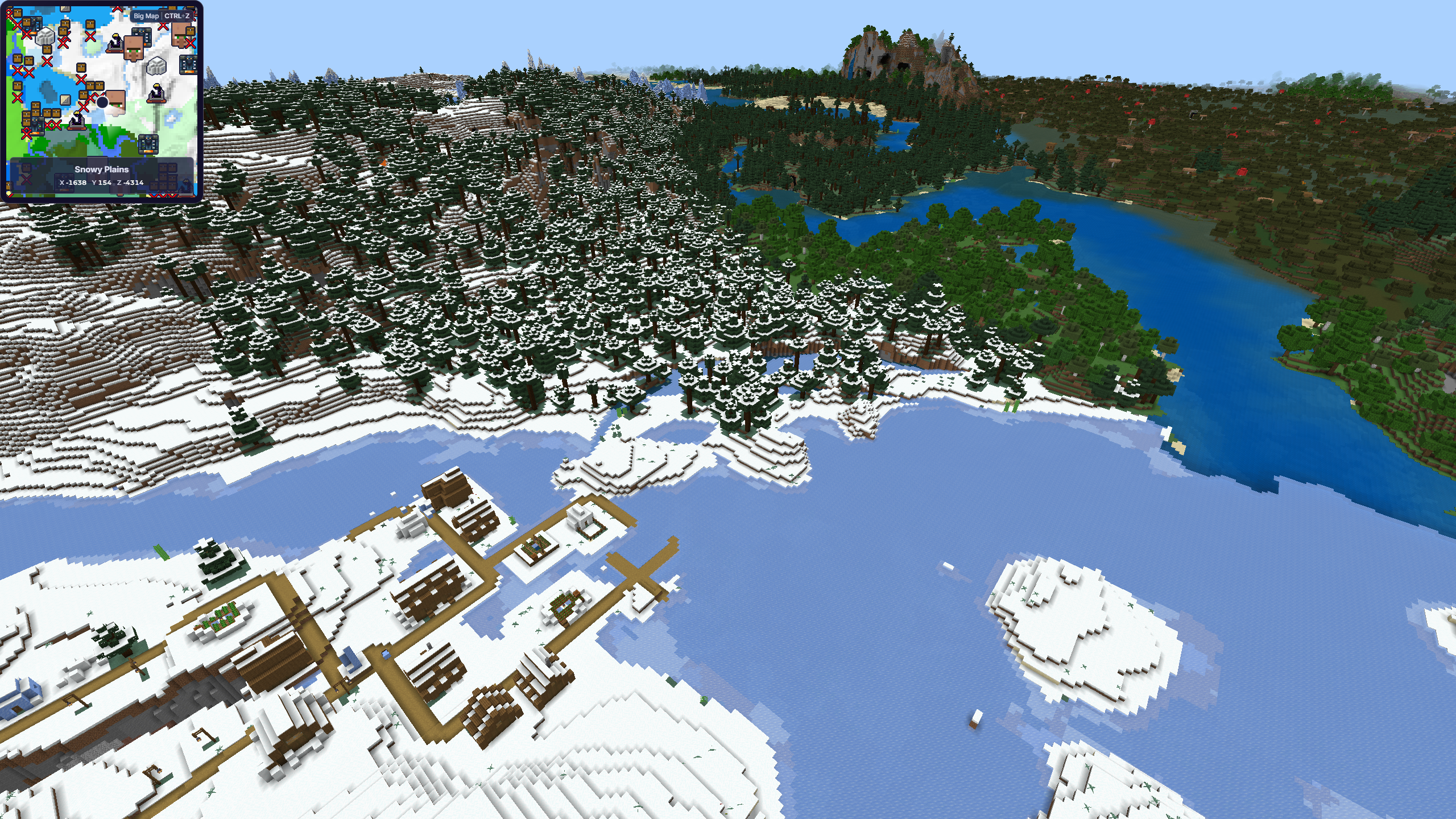 A high viewpoint showing snowy, forested, mountainous, and lakeside biomes meeting